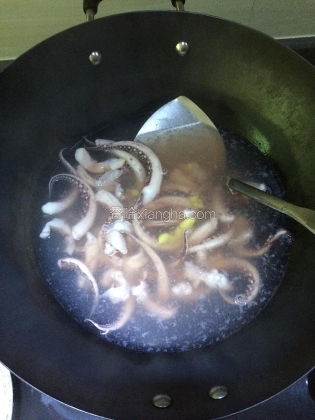 锅中倒入适量清水烧开，放入一部分姜片和料酒，水烧开后放入鱿鱼须在锅里煮一下，一分钟就可以捞起沥干水分备用。