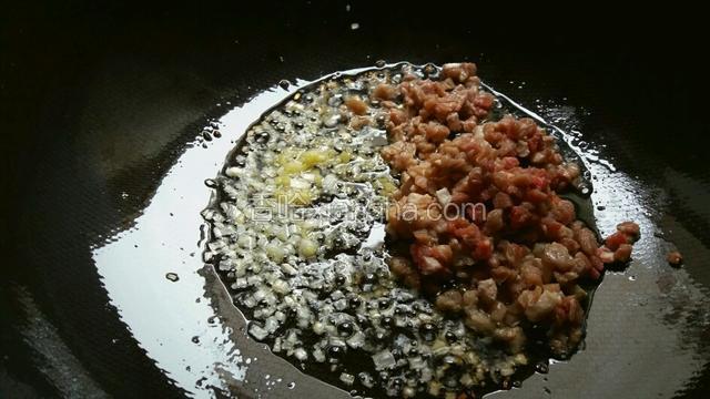 起炒锅放入菜籽油烧至微冒烟，然后关火，待油温凉至七成热复开火，中火下葱姜末、牛肉丁煸炒至没有水分。