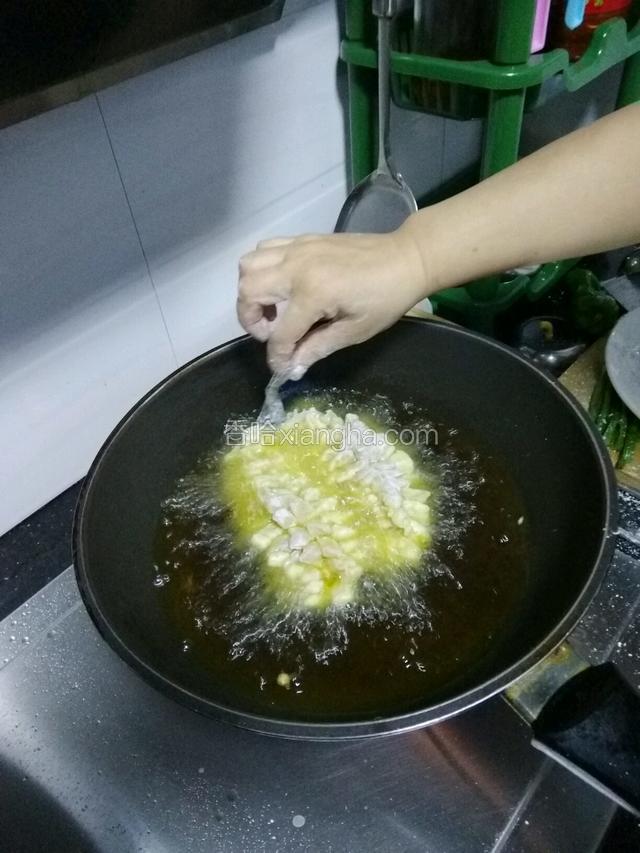 拿住鱼尾慢慢放入锅中