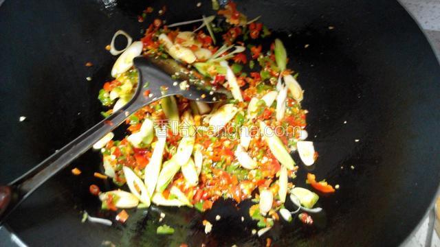 陆续放入姜、蒜、辣椒、青蒜白、豆豉炒香。