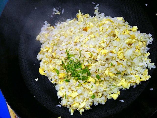 炒至锅中蛋和米饭均匀混合后，加适量的葱花。再加一勺食盐，半勺味精以调味。