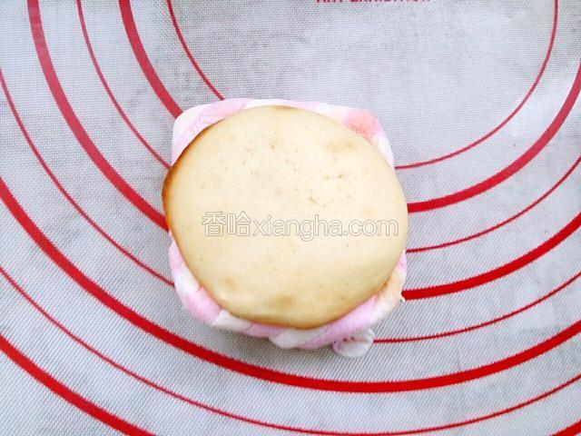 拿出来趁热用没有棉花糖蛋饼压在棉花糖上，用手往里推下周边棉花糖，为粘巧克力酱做准备