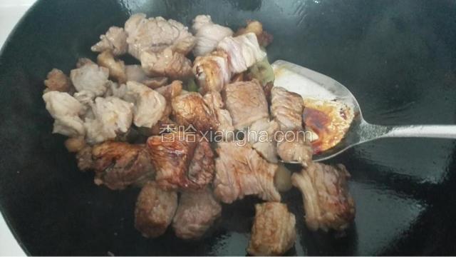 肉变白后加入料酒、蚝油、老抽，葱姜蒜搅拌均匀