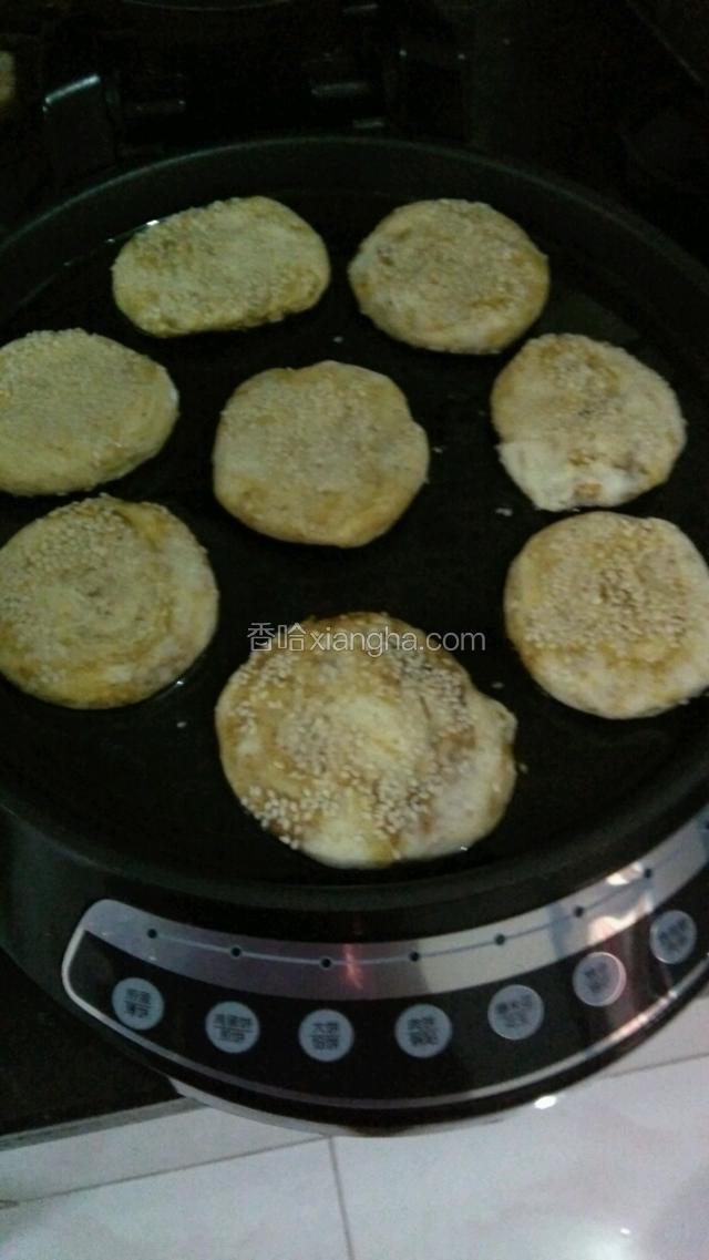 在饼上稍微沾点水，放在芝麻盘子里上下抹点
电饼铛里放油，把烧饼放入电饼铛，醒制10分钟。