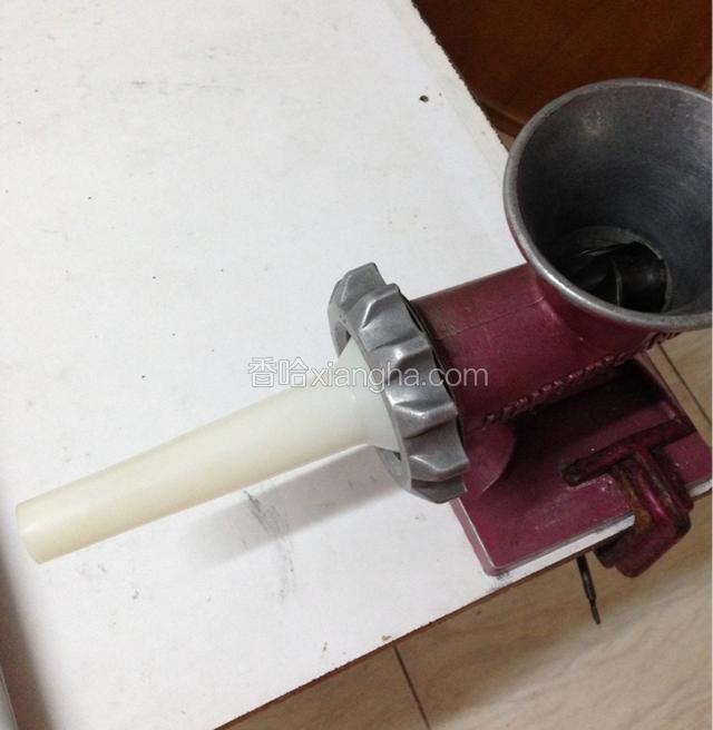 把灌香肠用的白色漏斗安装在绞肉机上
(绞肉机上的刀片必须取下来)