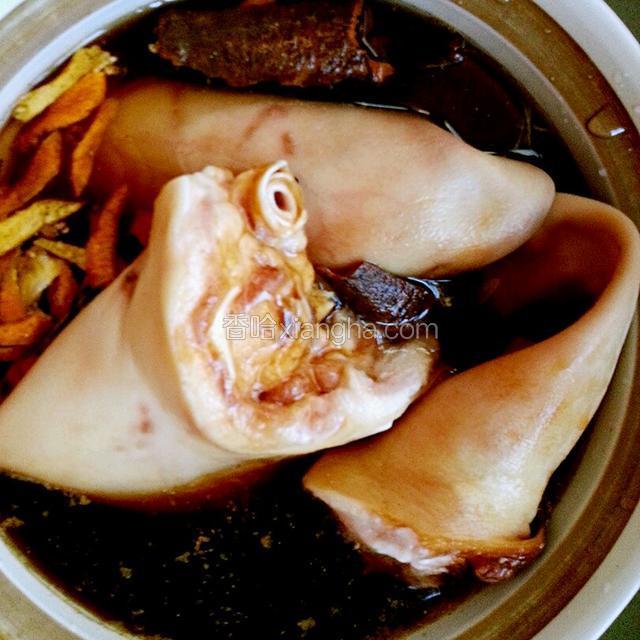 砂锅里放入水量与猪耳朵平行，可以适量的加入老卤水。大火煮沸后，转小火煮30分钟。

