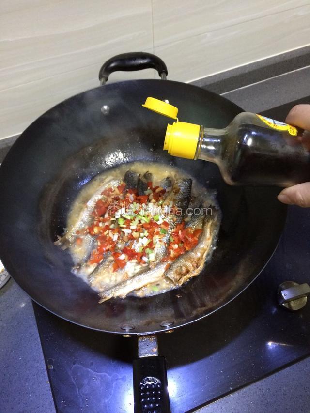然后加入剁椒，葱白，和半碗清水，继续焖至鱼干入味。加入生抽一起焖煮。