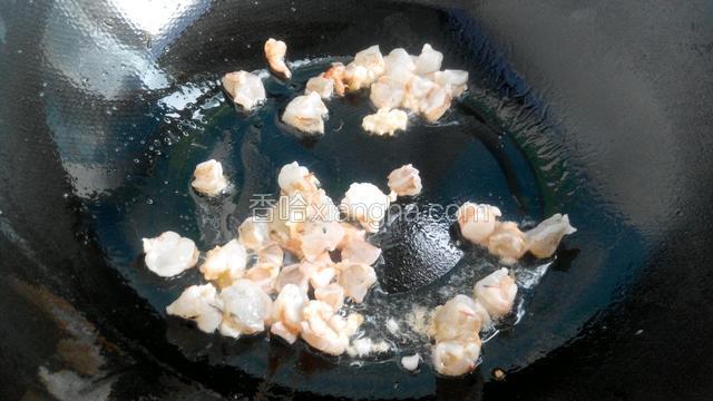 另起锅放油烧热后，倒入切好的虾翻炒变色。