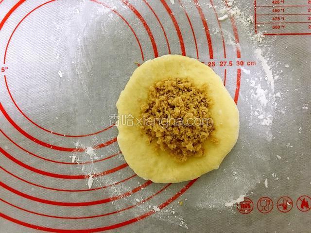 
把松弛后的小面团擀成中间厚，四面薄的面皮，包入肉松。（肉松也是我自制的，有单独的菜谱，有兴趣的可以参考）