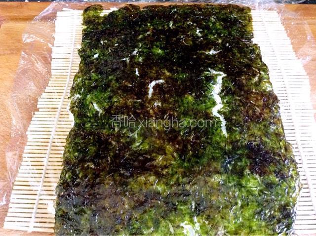 翻过来，海苔在上边，然后撕去保鲜膜。