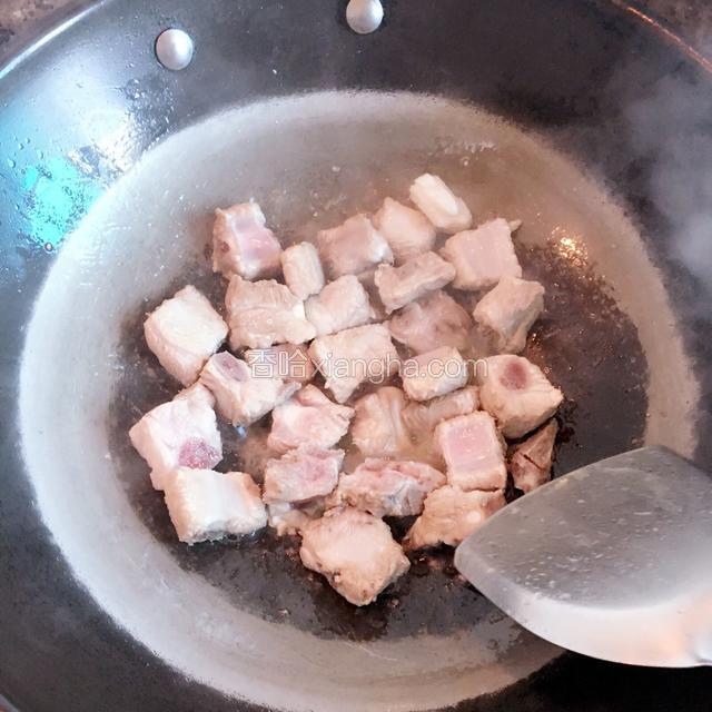 热锅放少许花生油，加入料酒略炒排骨。