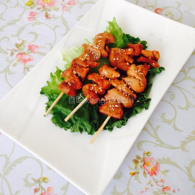 烤好在盘子里铺一片生菜，把肉串放上，撒少许芝麻，能闻到香味了吗，快来吃吧！