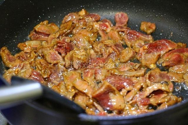 改大火，将牛肉滑入翻炒至変色，捞出沥油。