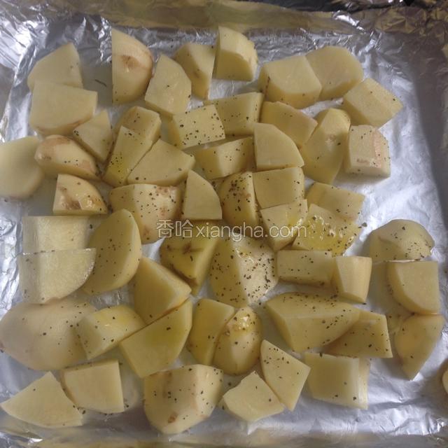 烤盘铺上锡纸，土豆去皮洗净切小块，放入烤盘，淋一点橄榄油撒上一点盐和黑胡椒碎，用筷子稍微拌一下