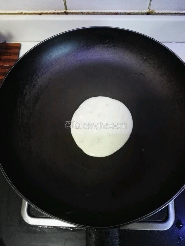 将平底不粘锅小火加热，不用放油，舀入一大勺面糊。
