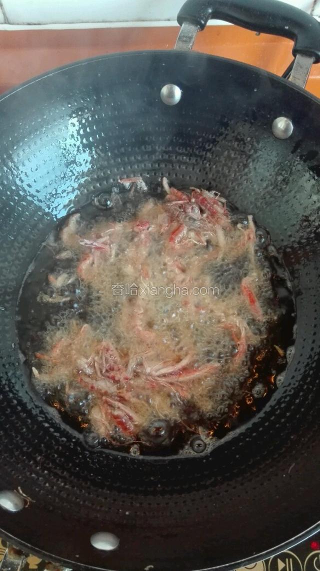 把河虾倒入油锅中，用筷子划散。