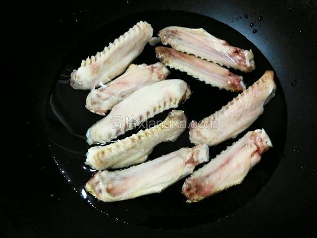 鸭翅去尽残毛，洗净，从关节处斩成段，留用翅根部分。入加食盐的凉水锅内焯除血水，捞出清洗干净。