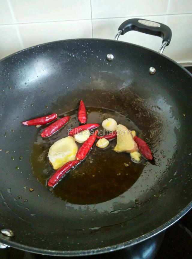 锅中加入适量菜籽油，油热后放生姜蒜头干红椒煸炒片刻