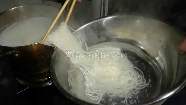 把米粉捞入装满凉水的盆子。