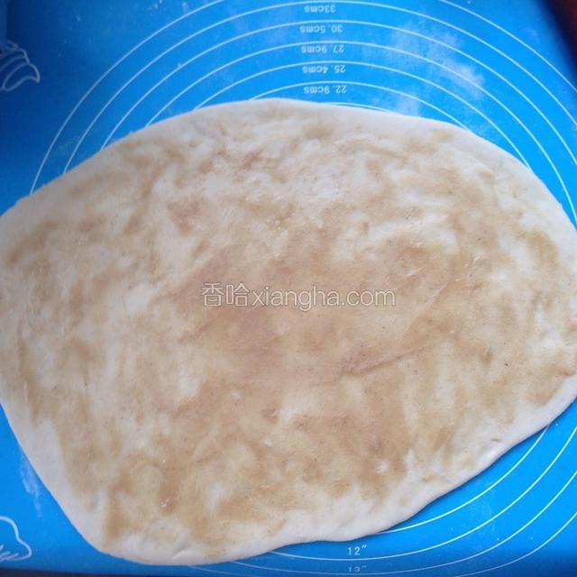 将面团擀成饼状，把做好的油酥涂抹在饼皮上