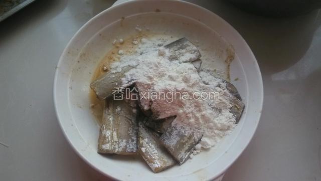 腌制好的带鱼倒去腌汁，加入干面粉