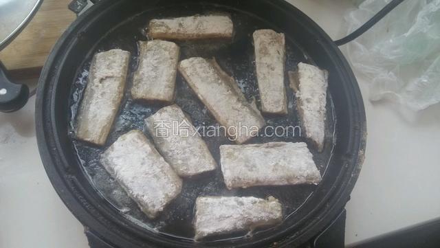 将带鱼逐个放入电饼铛煎，放入后不要乱动，待其自然煎好能滑动。