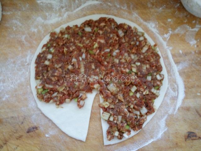 用擀面杖擀开，在一边处切一囗，然后放入羊肉馅，留一角不放馅