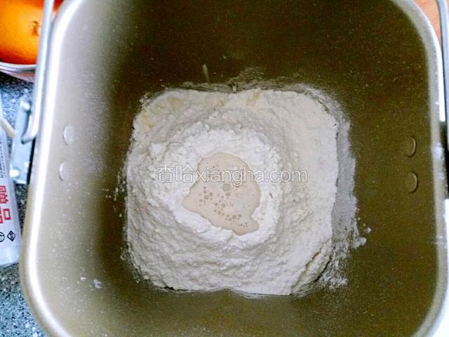 在面粉中戳个坑，把提前化开酵母倒进小坑中