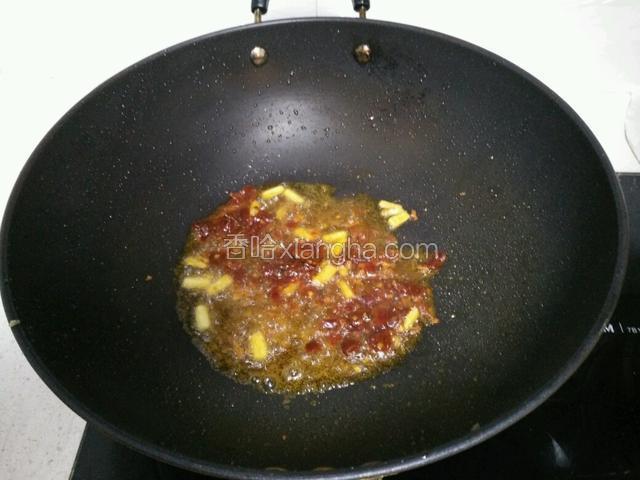 锅里留底油烧热，加入姜粒、豆瓣酱炒出香味。
