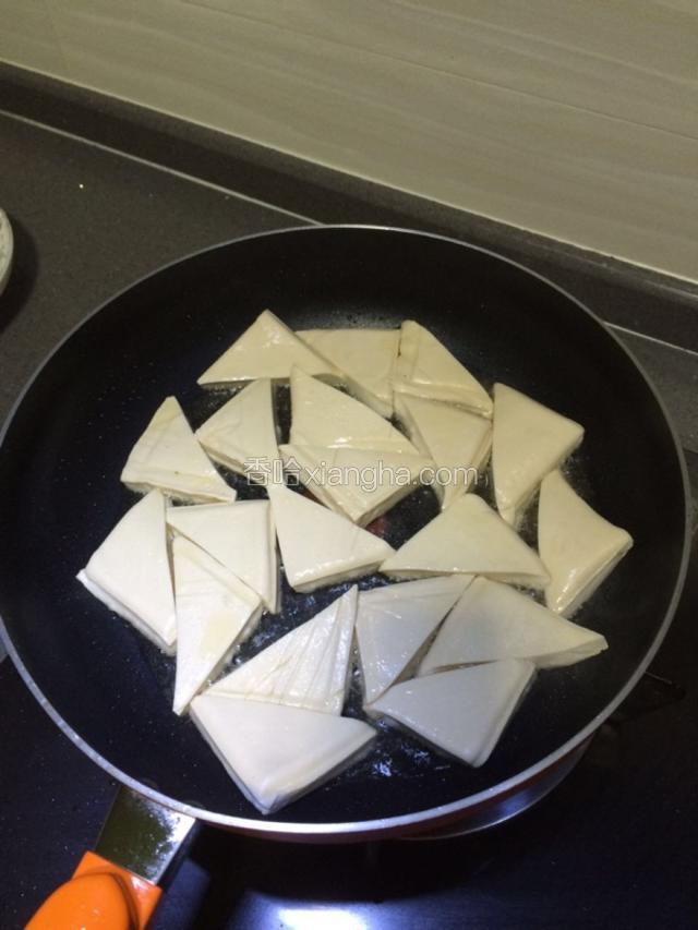 锅中放入适量油，把豆腐放入锅中开始煎。中小火煎。