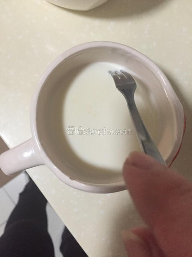 晾凉后，你会发现表面有一层厚奶皮，用叉子在边缘扎破。