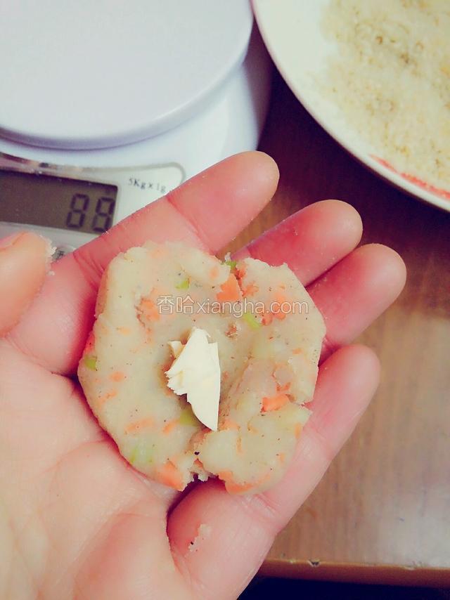取一小球土豆泥，大约15克，用手按扁，放入芝士碎，包好，团圆