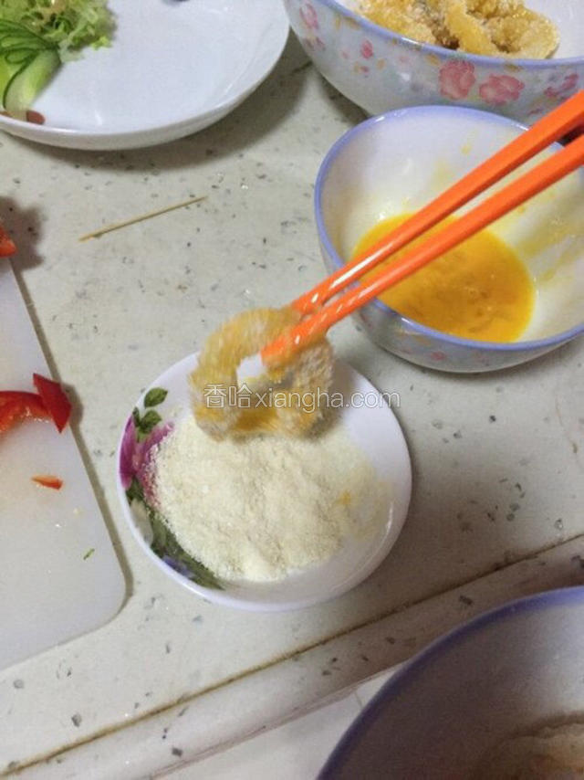 蘸了鸡蛋液的鱿鱼圈裹上椰蓉。