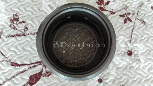 电饭煲中倒入适量水，插电将其烧开。