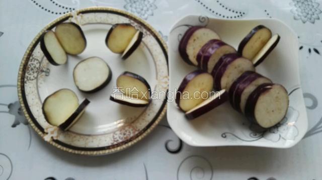 茄子洗净去水、去两端，然后第一刀切0.5cm厚片，但不要切断，只切2/3深即可；第二刀再切0.5cm厚片，直接切断，两片是夹子壮。