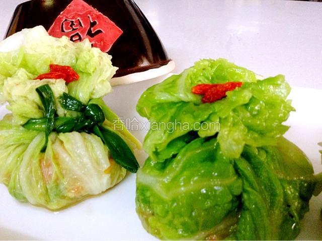 取一片菜叶包入炒好的馅料，用韭菜捆好，放上枸杞做点缀。（韭菜或菠菜都可以，用水烫一下）
