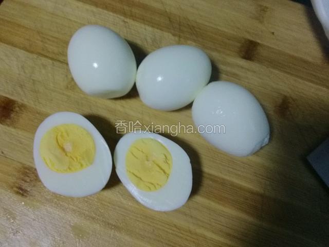 鸡蛋冷却后去壳，用菜刀一分为二。