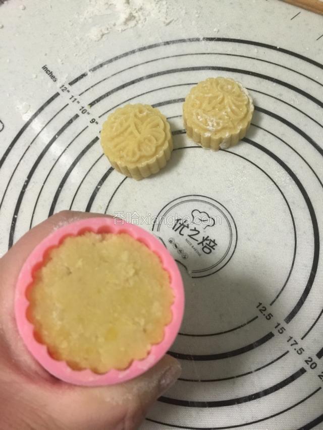 模具放入少量蒸熟的中筋面粉，放入炒好的绿豆泥！按压成型！