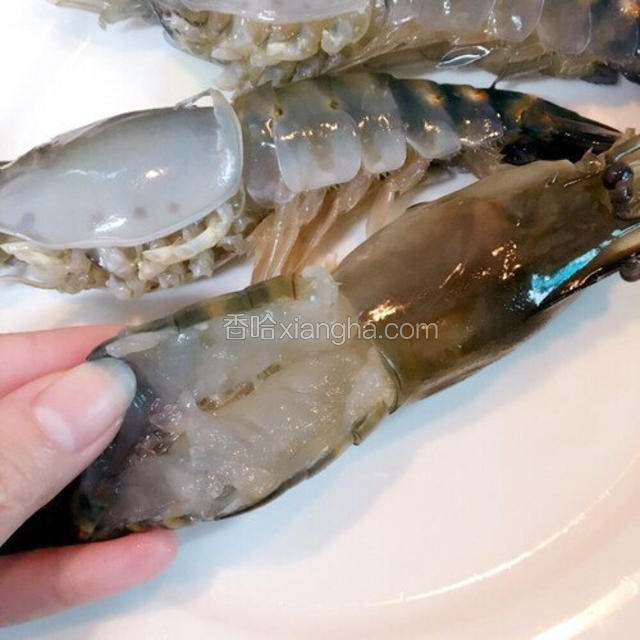 把大虾头尾连接处剪开、开背、挑出虾肠。滴几滴白酒腌一下虾肉
