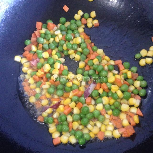 依次倒入焯过水的玉米和青豆偏炒