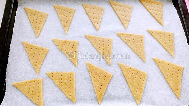 烤箱170度预热，用叉子在三角形的面片上扎一些小孔。