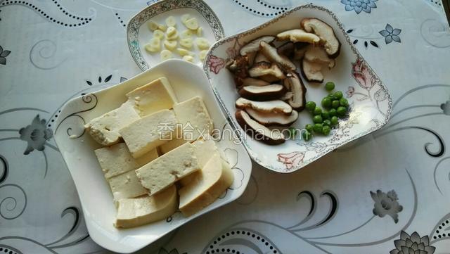 豆腐、蒜切片，香菇洗净去蒂切片；豌豆焯水2分钟捞出备用
