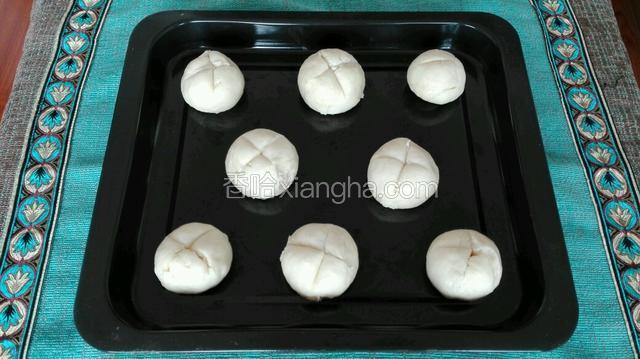 奶香馍晾冷后，用刀在顶部位置切上两刀，放于烤盘内。