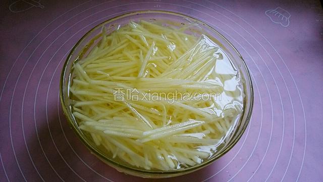土豆擦丝放入清水里侵泡去淀粉，捞出沥干水备用。