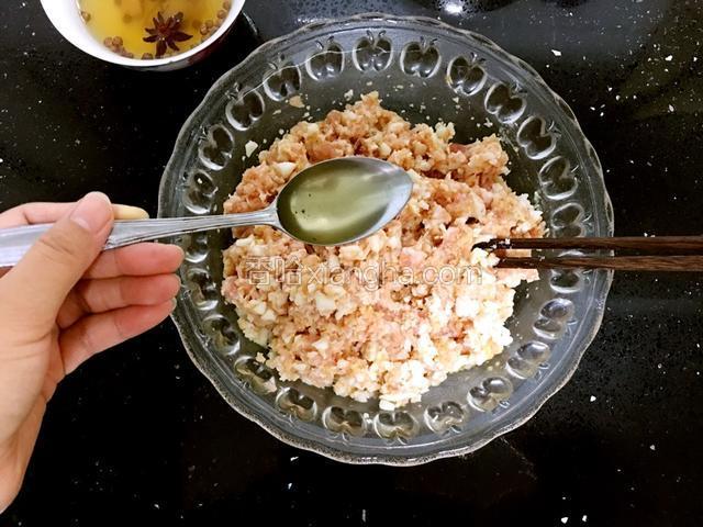 花椒水逐步加入肉馅搅拌。这样做出的丸子内部很嫩。