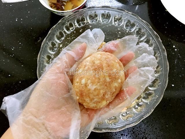 手带一次性手套舀一大勺肉馅，稍揉成丸子后在兩手掌间來回轻轻拍打，將內部空气排出，这样做成的丸子结实一点。都揉成均等大小的肉丸。（这是8个的量）