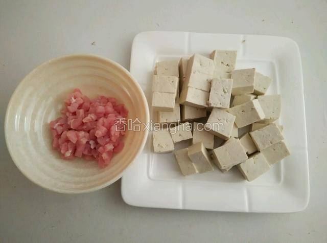 先把瘦肉切丁，再把豆腐切块用开水煮一遍捞出来备用