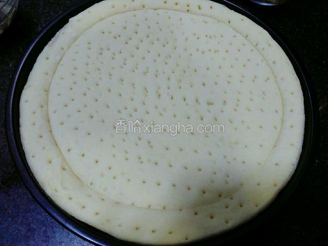 将解冻后的披萨饼皮放入披萨盘中。