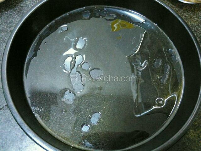 披萨盘底和壁用刷子均匀地刷上一层食用油。这时可以提前将烤箱200℃上下火预热10分钟。