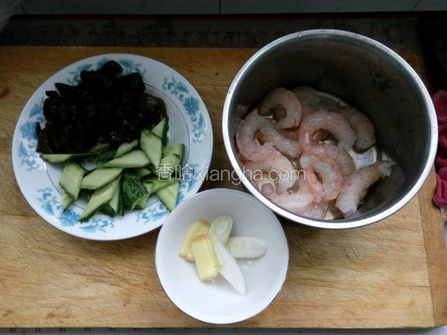 准备食材，木耳提前泡发洗净，黄瓜洗净切片，虾仁用凉水解冻去掉虾线备用，葱姜切段